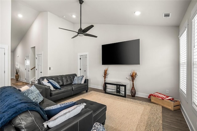 living room featuring visible vents, dark wood-style flooring, baseboards, ceiling fan, and vaulted ceiling