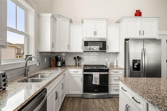kitchen featuring a sink, appliances with stainless steel finishes, decorative backsplash, and white cabinetry