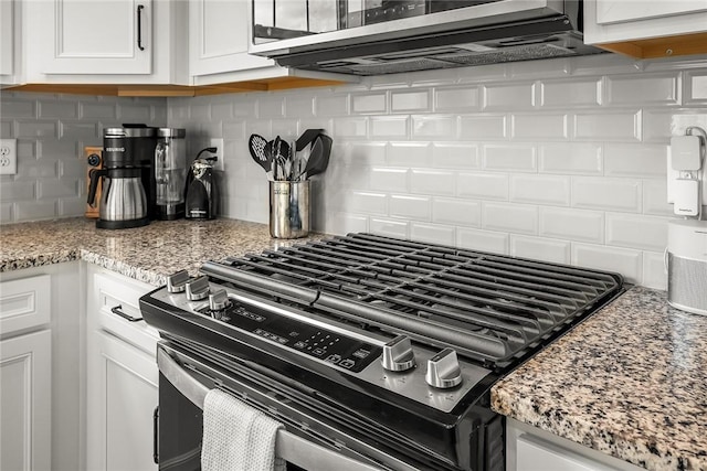 kitchen with light stone counters, white cabinetry, appliances with stainless steel finishes, and backsplash