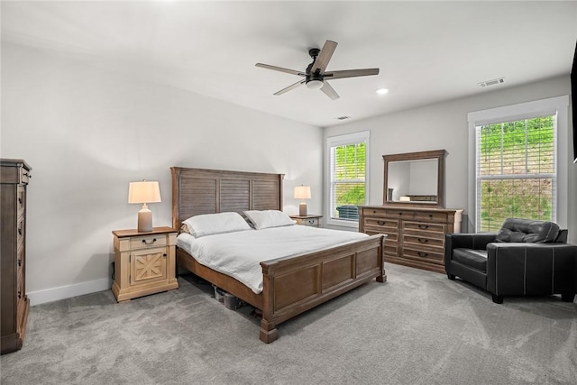 bedroom with visible vents, a ceiling fan, baseboards, and light carpet