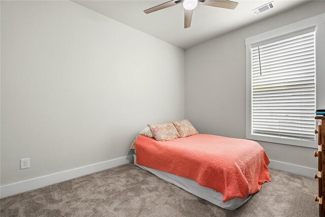 carpeted bedroom with baseboards, a ceiling fan, and visible vents