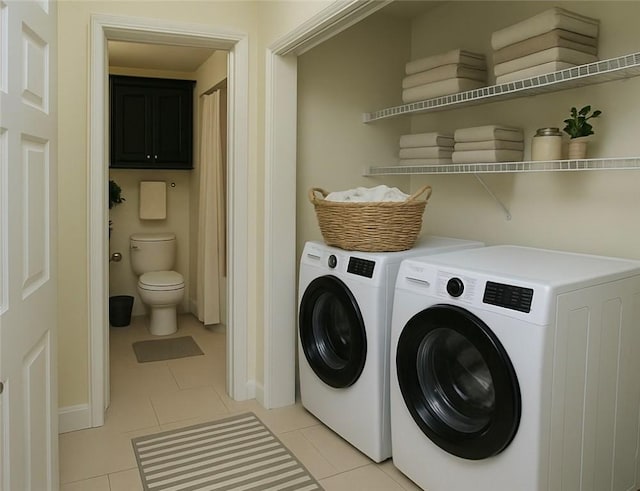 laundry room featuring washing machine and clothes dryer, laundry area, baseboards, and light tile patterned floors