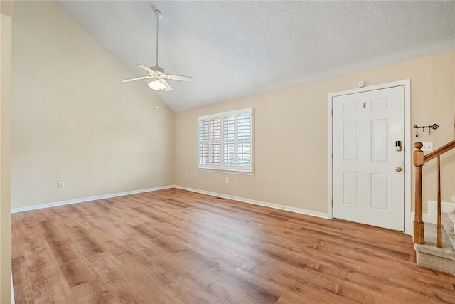 unfurnished room featuring baseboards, ceiling fan, light wood-type flooring, and stairs