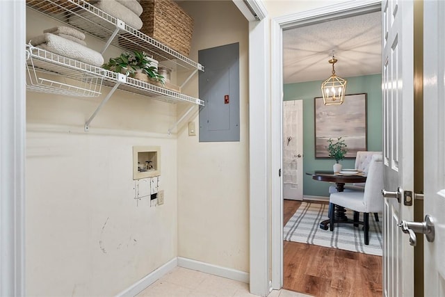 clothes washing area featuring baseboards, electric panel, and hookup for a washing machine