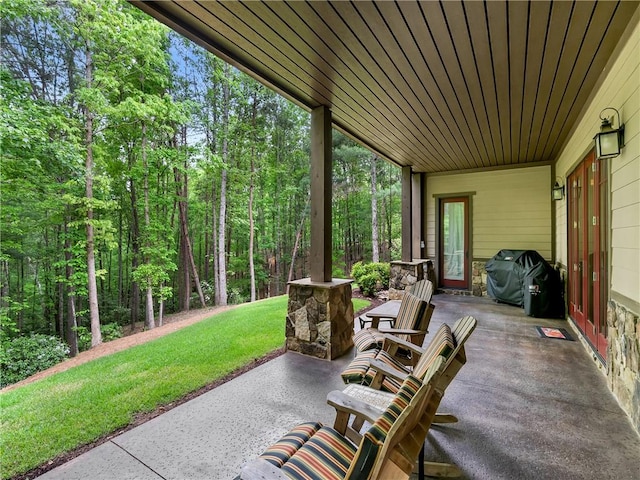 view of patio with area for grilling and a forest view