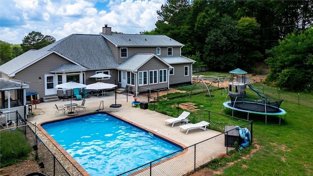 view of swimming pool with entry steps, a trampoline, a fenced backyard, and a patio