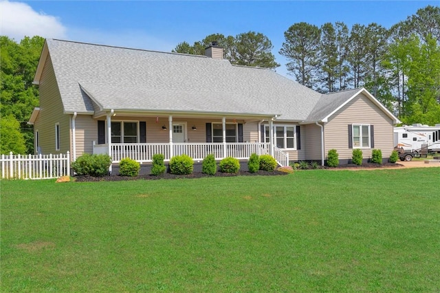 view of front of house featuring covered porch, a chimney, a front yard, fence, and a shingled roof