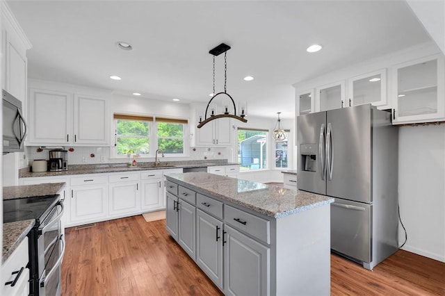 kitchen with a sink, white cabinetry, appliances with stainless steel finishes, and a kitchen island