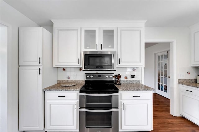 kitchen with appliances with stainless steel finishes, white cabinets, and backsplash