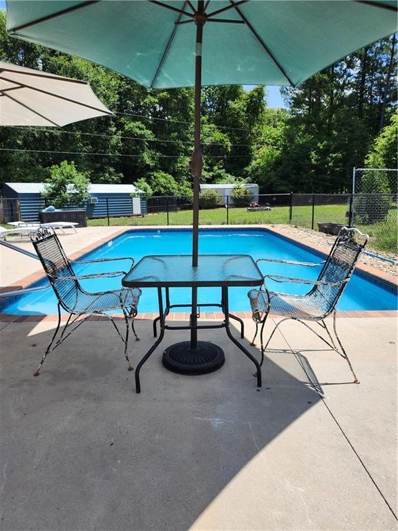 view of swimming pool with fence, a fenced in pool, and a patio area