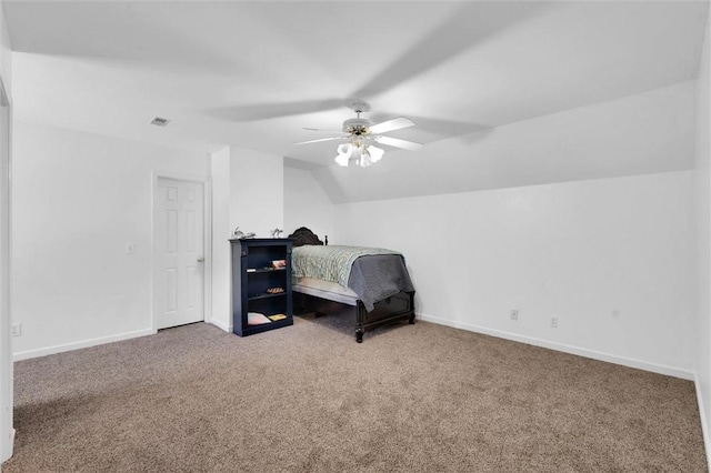 carpeted bedroom featuring a ceiling fan, baseboards, visible vents, and vaulted ceiling