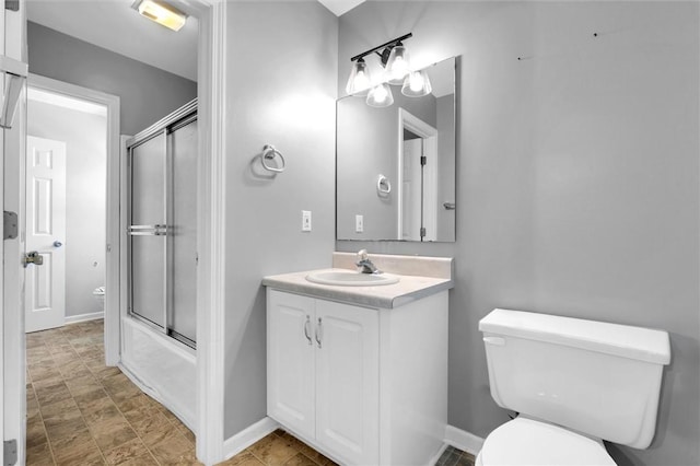 full bathroom featuring toilet, baseboards, shower / bath combination with glass door, and vanity