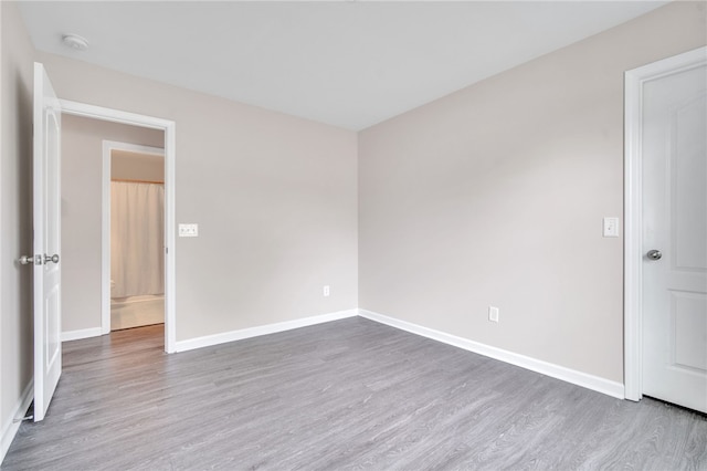 empty room with baseboards and wood finished floors