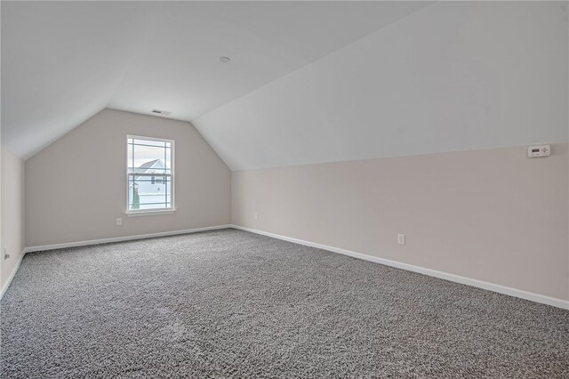 bonus room with carpet floors, baseboards, lofted ceiling, and visible vents