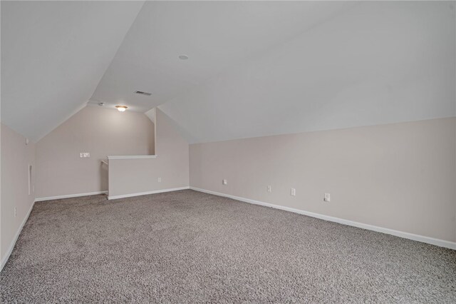 additional living space with carpet floors, baseboards, vaulted ceiling, and visible vents