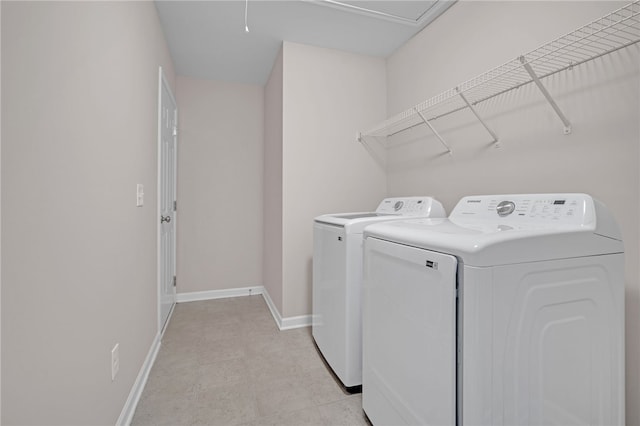 laundry area with baseboards, laundry area, independent washer and dryer, and light floors