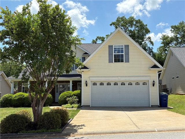 traditional home with a garage, driveway, and cooling unit