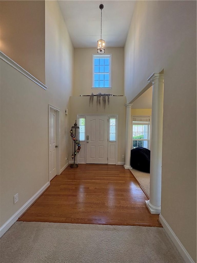 entrance foyer featuring baseboards, a high ceiling, and decorative columns