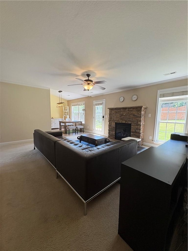 living room with carpet floors, visible vents, baseboards, a stone fireplace, and a ceiling fan
