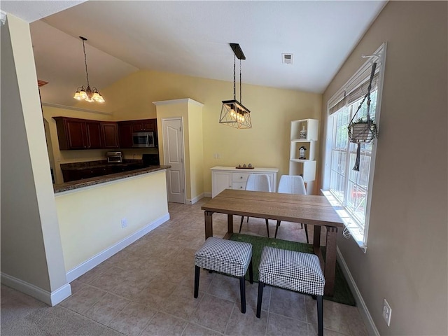 dining area with a chandelier, baseboards, light tile patterned floors, vaulted ceiling, and visible vents