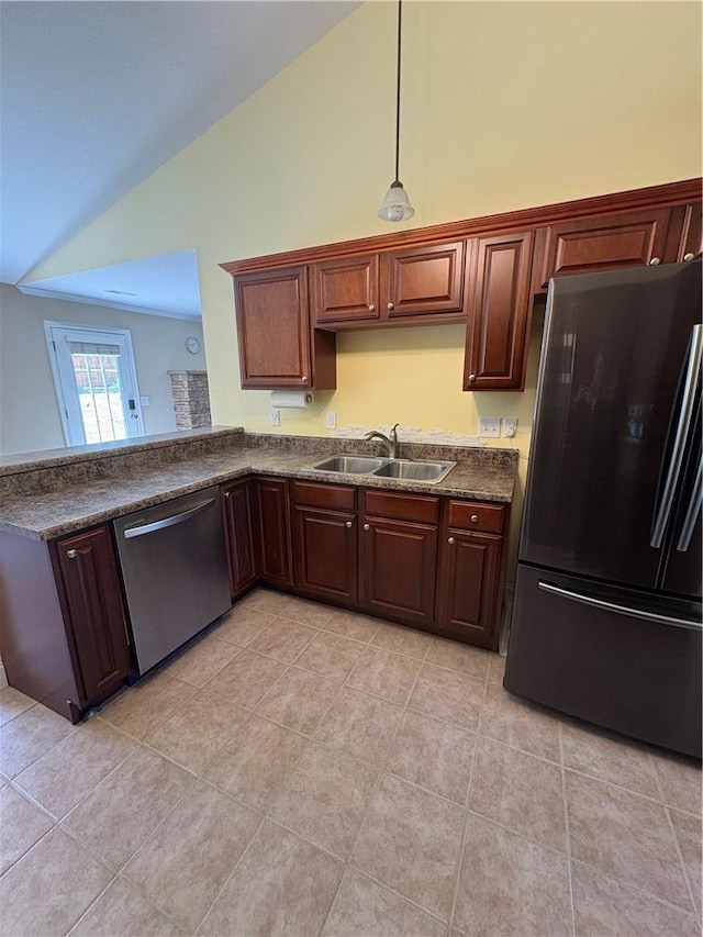 kitchen featuring dark countertops, stainless steel dishwasher, a sink, freestanding refrigerator, and lofted ceiling