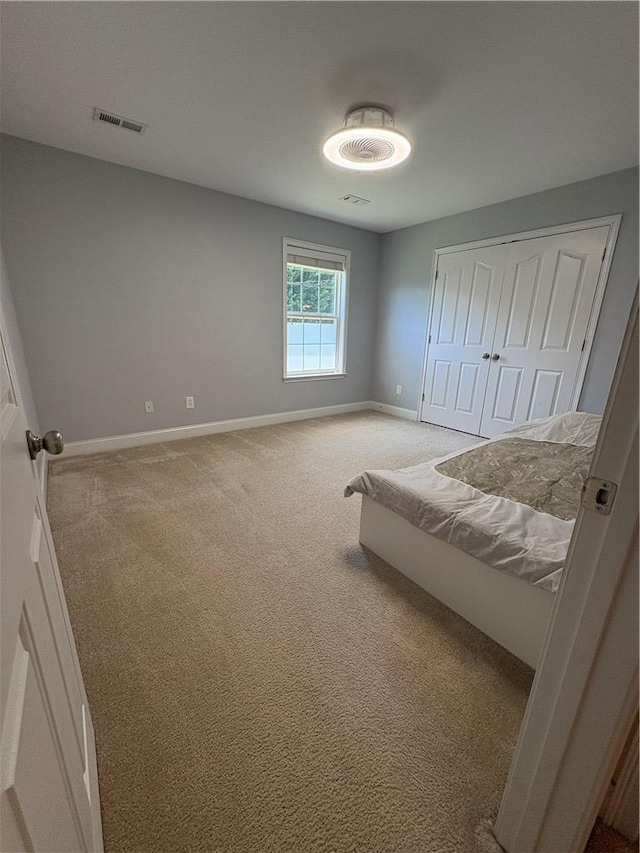 bedroom featuring baseboards, visible vents, carpet, and a closet