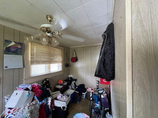 bedroom with wooden walls and ceiling fan