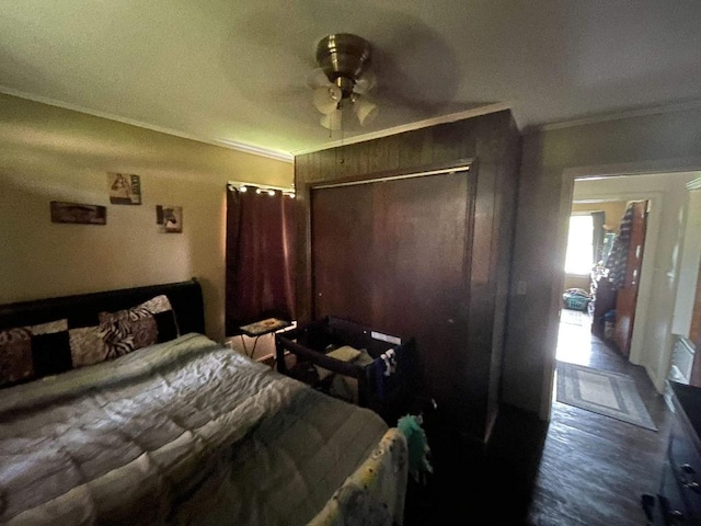 bedroom featuring crown molding, ceiling fan, a closet, and wood finished floors
