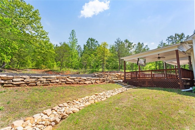 view of yard with a wooden deck and ceiling fan