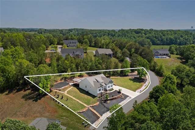 bird's eye view with a wooded view