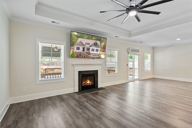 unfurnished living room with a fireplace with flush hearth, a raised ceiling, crown molding, and wood finished floors