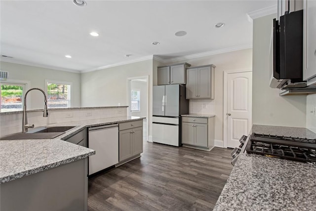 kitchen featuring gray cabinets, dishwasher, a sink, freestanding refrigerator, and dark wood-style floors