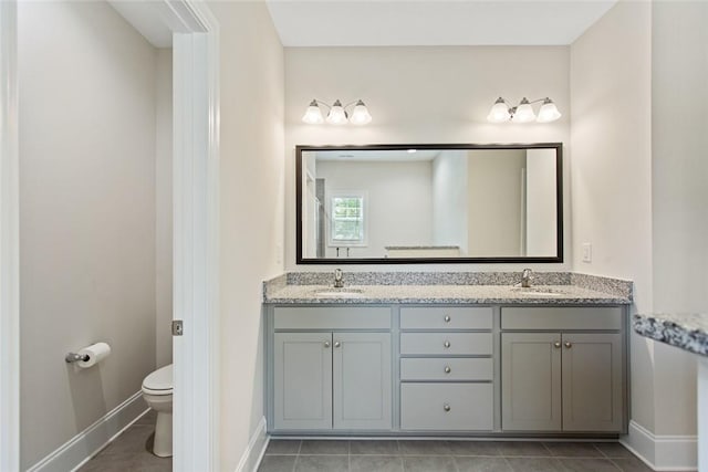 full bath featuring a sink, baseboards, toilet, and double vanity