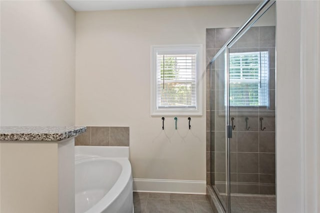 full bathroom with baseboards, a shower stall, tile patterned flooring, and a garden tub