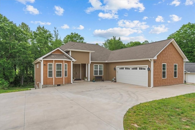 ranch-style home with roof with shingles, an attached garage, and concrete driveway