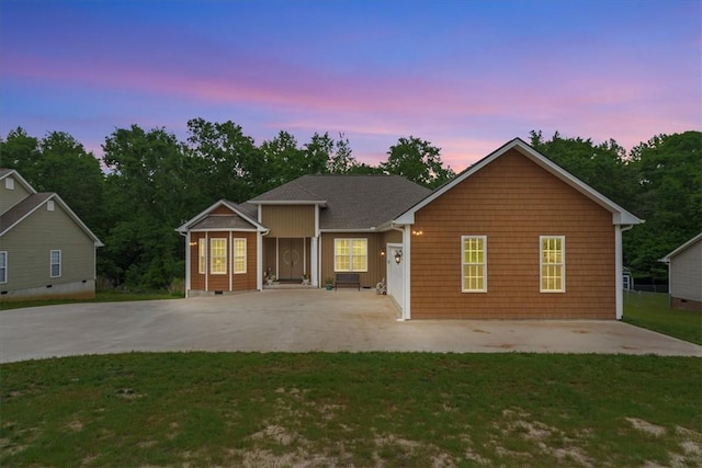 single story home with concrete driveway, a front yard, and a patio area