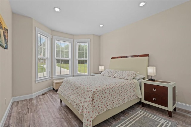bedroom with recessed lighting, baseboards, multiple windows, and wood finished floors