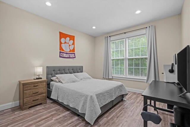 bedroom with recessed lighting, baseboards, and light wood-type flooring