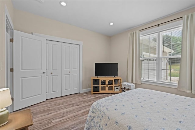 bedroom with baseboards, a closet, recessed lighting, and wood finished floors