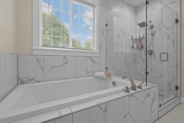 bathroom with a marble finish shower and a garden tub