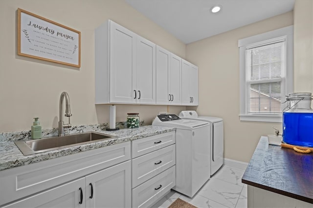 clothes washing area featuring marble finish floor, baseboards, washer and clothes dryer, a sink, and cabinet space