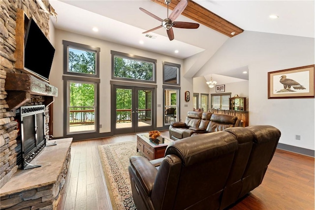 living area featuring a fireplace, a ceiling fan, high vaulted ceiling, and wood finished floors