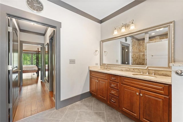 ensuite bathroom with a sink, double vanity, ensuite bathroom, and tile patterned flooring