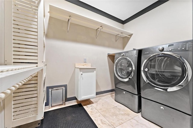 clothes washing area featuring baseboards and washer and clothes dryer