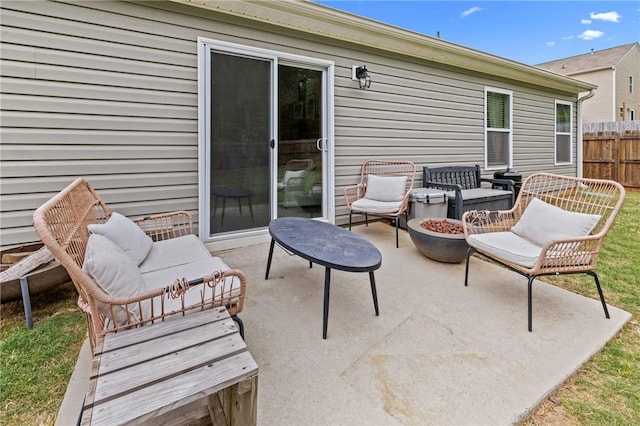 view of patio / terrace featuring an outdoor living space with a fire pit and fence