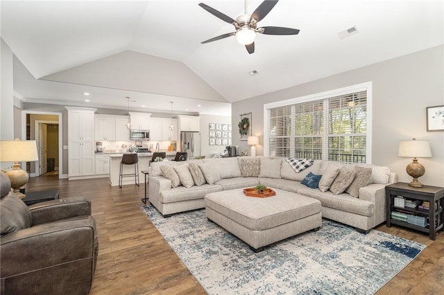 living area with vaulted ceiling, ceiling fan, visible vents, and wood finished floors
