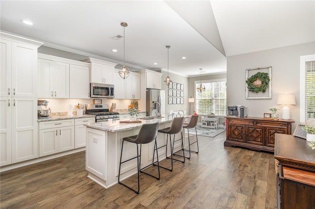 kitchen with dark wood-style flooring, a kitchen island with sink, appliances with stainless steel finishes, and white cabinets