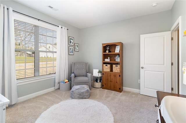 living area featuring carpet flooring, baseboards, plenty of natural light, and visible vents