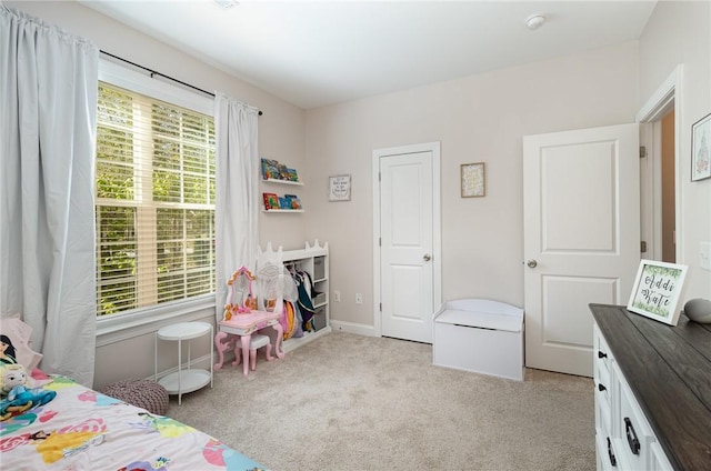 bedroom with baseboards and light colored carpet