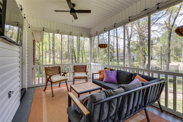 sunroom featuring ceiling fan, an outdoor living space, and a healthy amount of sunlight